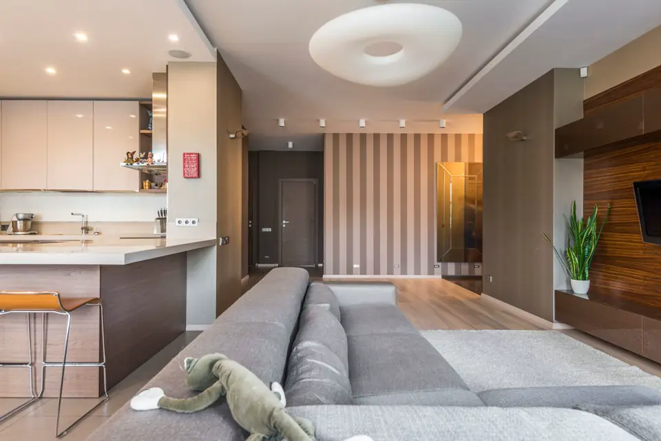 Departamento con cocina integrada y sillones grises