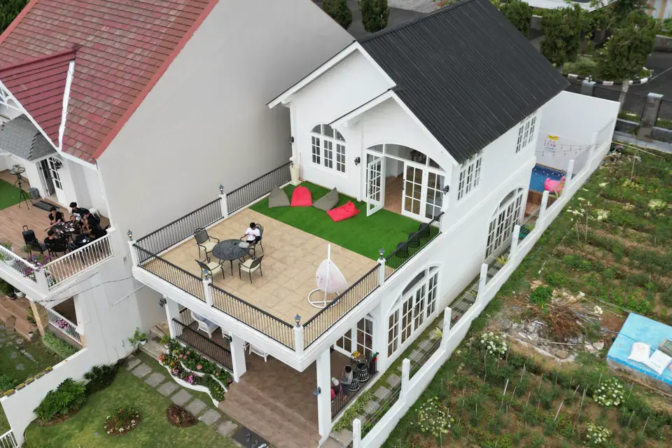 Vista aérea de una casa blanca con terraza y parque